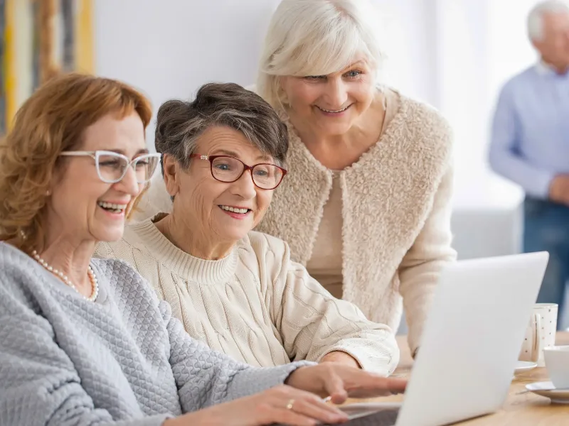 Home Tre donne sorridenti davanti a un computer portatile